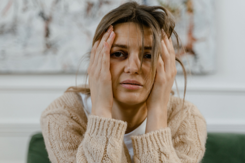 Frustrated Woman Struggling with Debt Holding Head in Hands